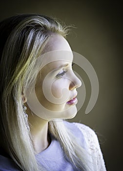 Profile portrait of gorgeous blonde lady lost in thought