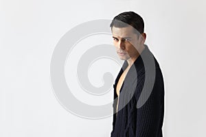 Profile portrait of handsome fit brunette young man in black sweater, isolated grey background. Horizontal view.