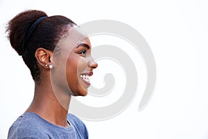 Profile portrait of happy young african woman laughing against isolated white background