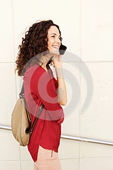 Happy young woman walking with mobile phone