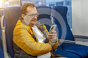 Profile portrait of mature positive guy in glasses in eyeglasses looking social media, texting messages using cell phone