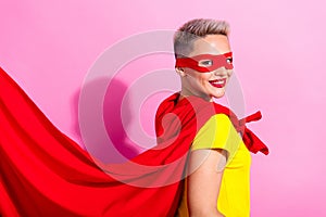 Profile portrait of satisfied pretty super girl beaming smile wear red cape mask isolated on pink color background