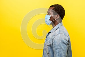 Profile portrait of serious young man with surgical medical mask looking left side with calm confident expression, blank copy