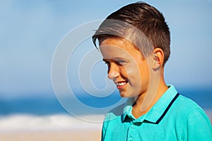 Profile portrait of a smiling boy on the sea beah