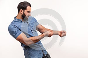 Profile portrait strong assertive man purposeful businessman with beard pulling invisible rope, showing his persistence and