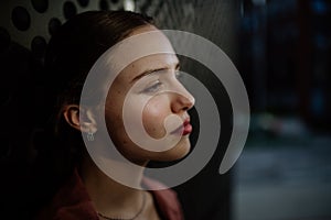 Profile portrait of stunning woman with green eyes. Headshot of woman standing in the darkness.