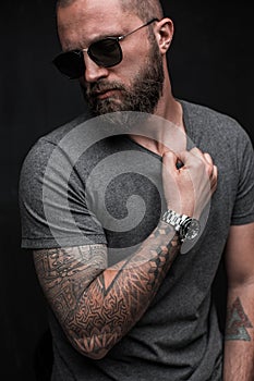 Profile portrait on turned head and long well trimmed beard of handsome man with sunglasses
