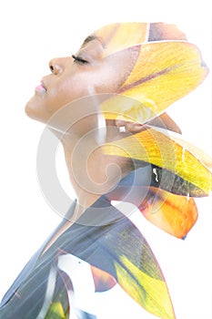 A double exposure profile portrait of a woman combined with an image of foliage.