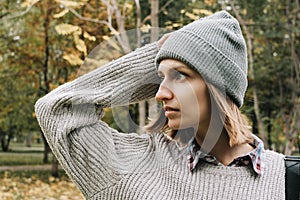 Profile portrait of young adult woman in grey hat and sweater