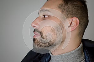 Profile portrait of a young brown-haired man with a short beard