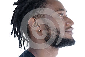 A profile portrait of a young man with dreadlocks