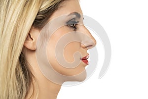 Profile portrait of a young woman with a humpbacked nose on a white background