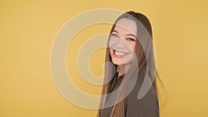 Profile portrait of a young woman laughing in camera