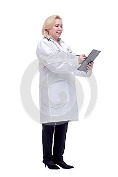 Profile of a pretty doctor with white lab coat, stethoscope smiling and writing notes in clipboard