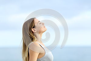 Profile of relaxed girl breathing fresh air on the beach