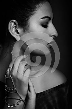 Profile shot of a beautiful young model holding touching her ear ring
