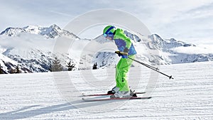 Profile shot of boy ski fast downhill over beautiful mountains