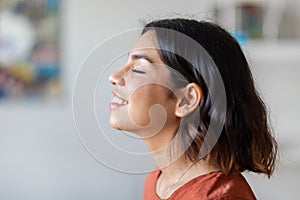 Profile Shot Of Delighted Young Arab Woman Smiling With Eyes Closed