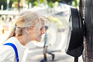 Profile side close-up view cute little blond kid girl enjoy fresh moisturized air blowing from big cooling fan machine