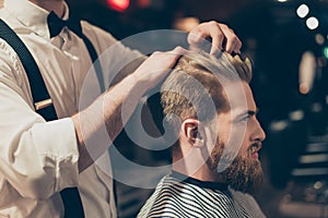 Profile side close up view portrait of handsome virile macho man having his hair cut in barbershop. Fashion hair care concept. Bea