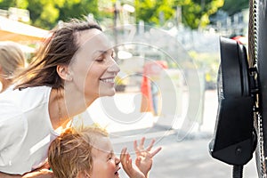 Profile side close-up view young adult woman with son enjoy fresh moisturized air blowing from big cooling fan machine