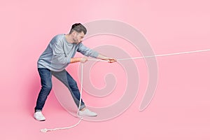 Profile side full length photo of determined guy ready pull string tug war conflict isolated on pastel color background