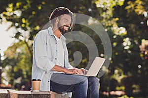 Profile side photo of charming young dank skin man sit work laptop wear glasses outside in park outdoors