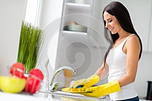 Profile side photo of neat positive housewife wash dishes after supper wearing yellow rubber protective gloves hold