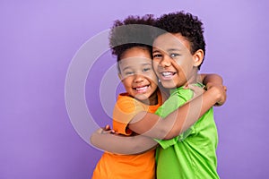 Profile side photo of two young little afro kids happy positive smile hug cuddle isolated over violet color background