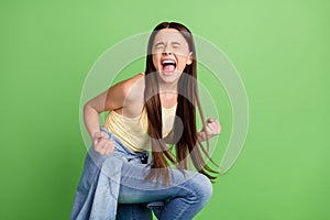 Profile side photo of young astonished girl happy positive smile rejoice victory fists hands isolated over green color