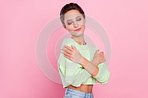 Profile side photo of young attractive girl happy positive smile hug cuddle herself comfort isolated over pink color