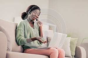 Profile side photo of young cheerful african girl happy positive smile talk speak videocall laptop headphones microphone