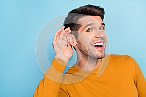 Profile side photo of young cheerful man happy positive smile eavesdrop listen gossip isolated over blue color