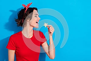 Profile side photo of young cheerful woman eat yummy organic fruit isolated over blue color background