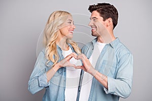 Profile side photo of young couple happy positive smile showing fingers heart symbol love feelings isolated over grey