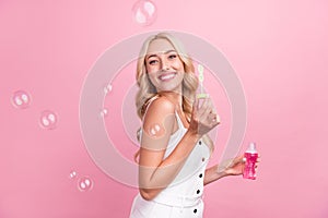 Profile side photo of young girl happy positive smile air fly soap bubbles  over pink color background