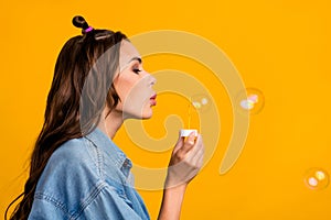 Profile side photo of young pretty woman blow bubbles free-time isolated over yellow color background