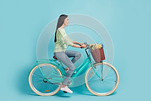 Profile side view of attractive cheerful girl riding bike rest free time isolated over bright blue color background