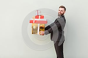 Profile, side view businessman toothy smile and holding gift box