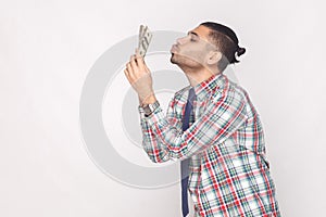 Profile side view of cheerful rich handsome bearded young stylish businessman in colorful checkered shirt standing and air