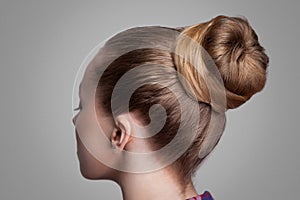 Profile side view closeup portrait of woman with creative elegant brown collected hairstyle, bun hair