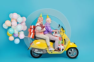 Profile side view of elderly retired pensioner cheerful couple riding bike decor deliver isolated over bright blue color