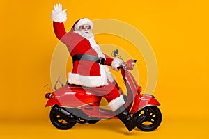 Profile side view of his he nice funny cheerful cheery white-haired Santa riding moped fast speed hurry up rush having