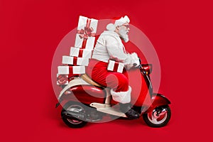 Profile side view of nice bearded focused funky fat Santa riding moped pile stack winter fairy purchases isolated on