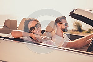 Profile side view portrait of attractive adorable cheerful couple riding car spending honey moon weekend rest free time