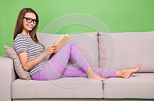 Profile side view portrait of attractive cheery brainy girl reading interesting book isolated over bright green color