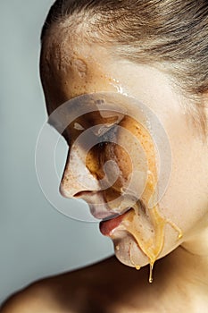 Profile side view portrait of beautiful young brunette woman with freckles and honey on face with closed eyes and smiley happy