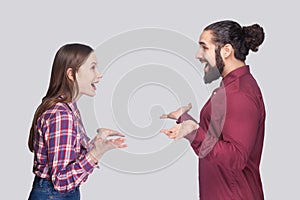 Profile side view portrait of funny surprised bearded man and woman in casual style standing and looking at each other with amaze