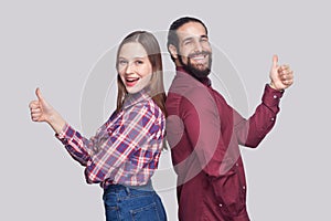 Profile side view portrait of happy satisfied bearded man and woman in casual style standing and looking at camera, smiling with