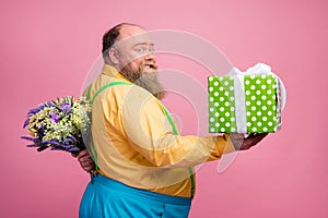 Profile side view portrait of his he nice romantic careful funky glad bearded guy giving you giftbox hiding flowers